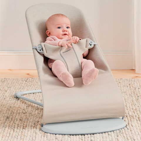Bebe sentado en una hamaca bliss de Babybjorn color beige